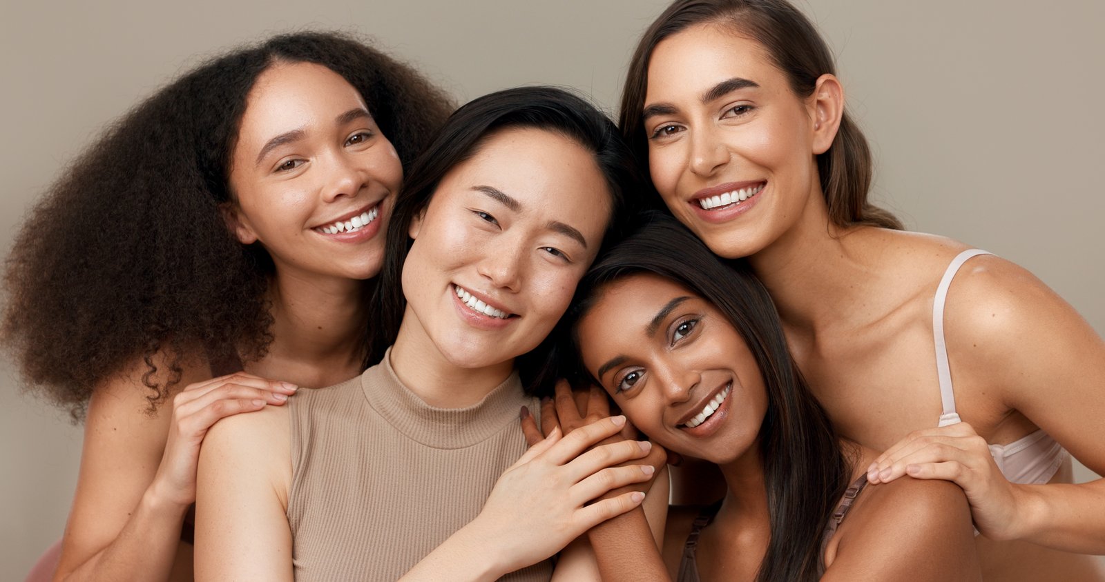 Group of women with a range of skin tones smiling together